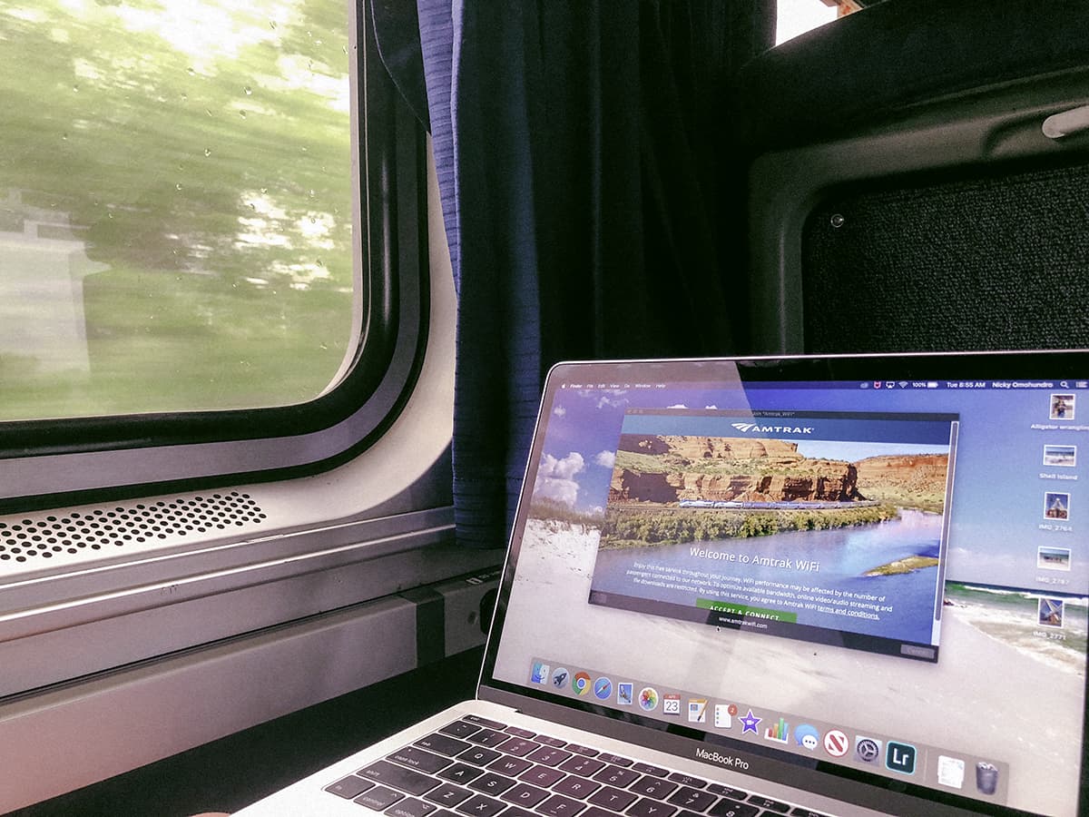 laptop with amtrak wifi displayed on screen next to a train window