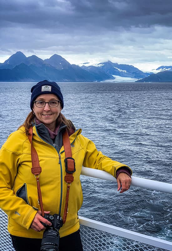 woman standing against ship railing in alaska