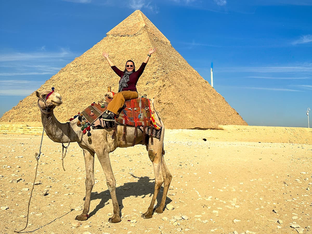 woman on on camel in front of Egyptian pyramid