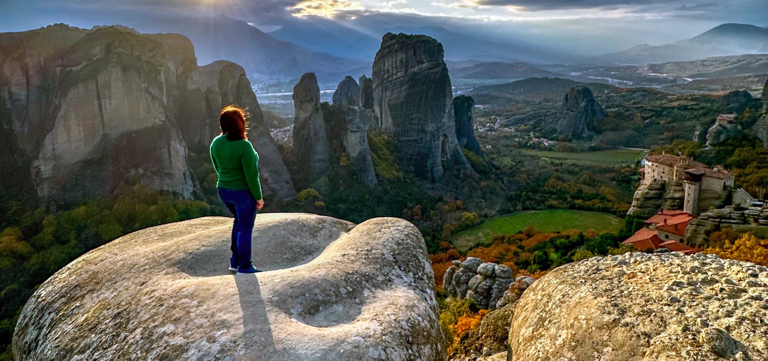 woman standing on a rock in Greece overlooking valley