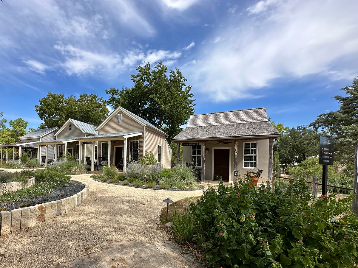 cottages inside a green garden with blue sky above